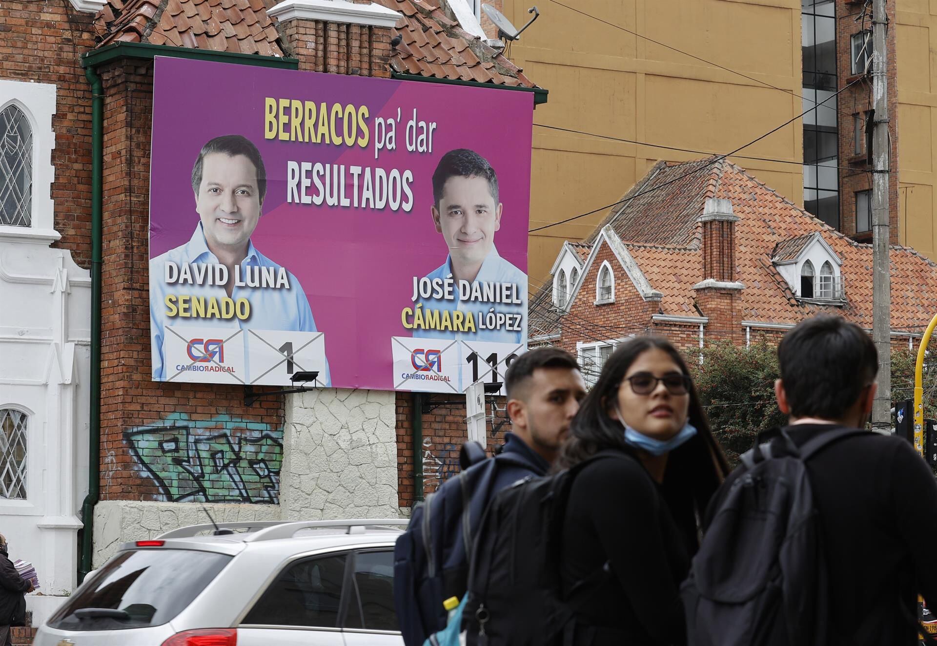 Several people pass in front of electoral propaganda.  Colombians will elect the entire Senate and the House of Representatives on March 13.  (EFE/ Mauricio Dueñas Castañeda).