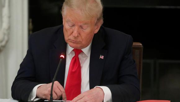 Se ve al entonces presidente de Estados Unidos, Donald Trump, tocando la pantalla de un teléfono móvil en Washington, el 18 de junio de 2020. (REUTERS/Leah Millis).