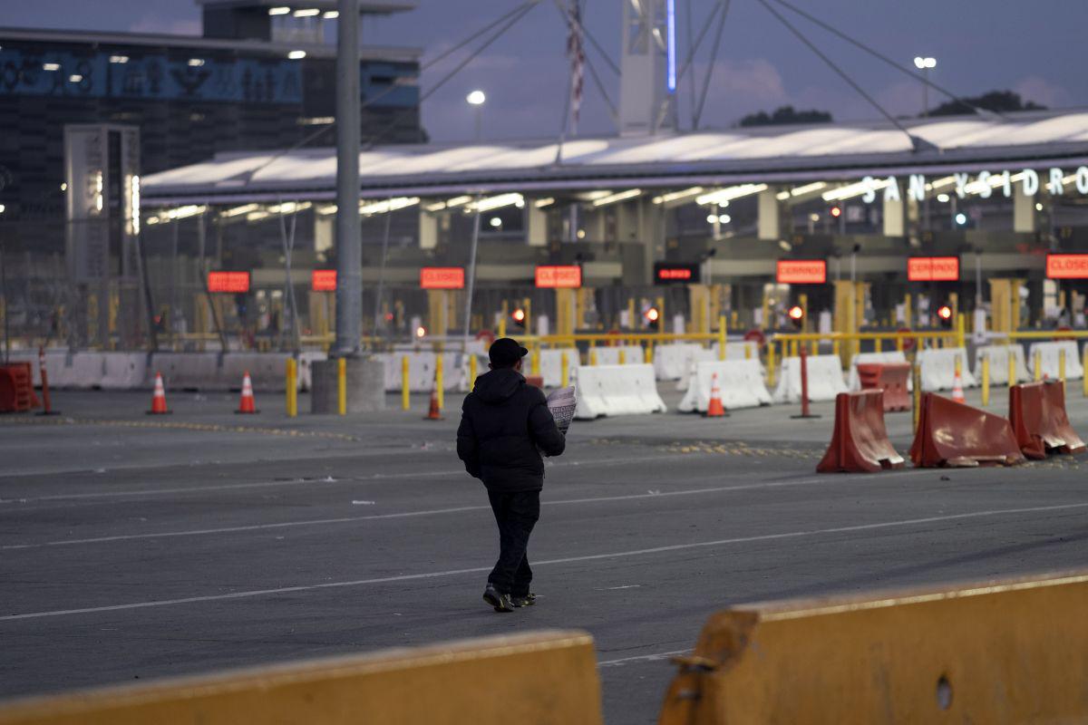 Un vendedor ambulante camina cerca de carriles cerrados en el puerto de entrada de San Ysidro en la frontera México-Estados Unidos, visto desde Tijuana, estado de Baja California (Foto: AFP)