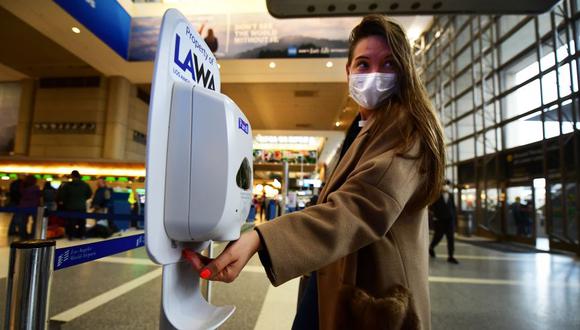 Una mujer usa desinfectante para manos a su llegada al Aeropuerto Internacional de Los Ángeles. (Foto: AFP/Archivo).