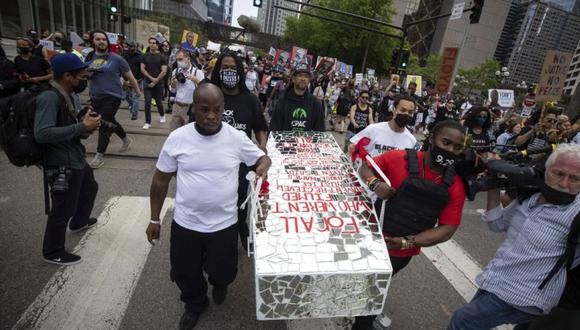 La gente lleva un ataúd simbólico en una manifestación y marcha por el primer aniversario de la muerte de George Floyd en Minneapolis, Minnesota. (Foto: AP/ Christian Monterrosa)