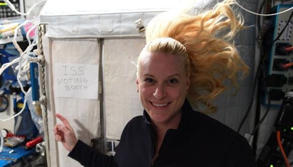 Esta foto del 22 de octubre de 2020 muestra a Kate Rubins, astronauta de la Estación Espacial Internacional (ISS), señalando un letrero que dice "cabina de votación de la ISS". (AFP).