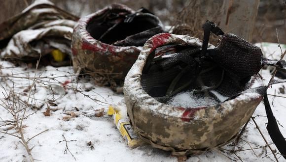 Cascos de militares ucranianos con manchas de sangre al costado de la carretera, en Soledar, región de Donetsk, el 14 de enero de 2023, en medio de la invasión rusa de Ucrania. (Foto referencial de Anatolii Stepanov / AFP)