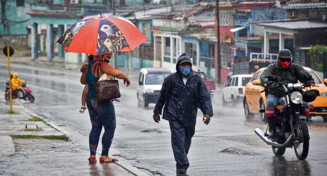 La gente camina bajo la lluvia en La Habana cuando el huracán Ida pasa por el este de Cuba. (Foto: ADALBERTO ROQUE / AFP).