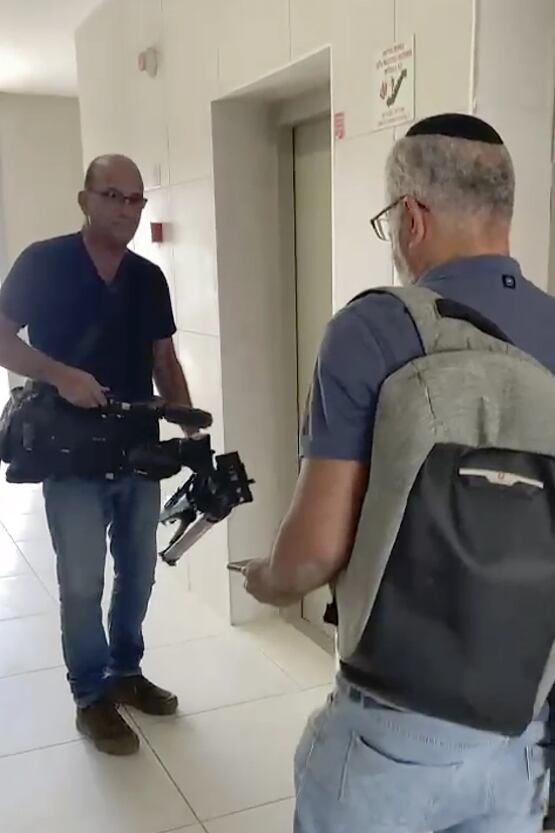 En esta imagen de video, funcionarios israelíes confiscan equipos de video de AP en un bloque de apartamentos en Sderot, sur de Israel, el martes 21 de mayo de 2024. (Foto AP/Josphat Kasire)