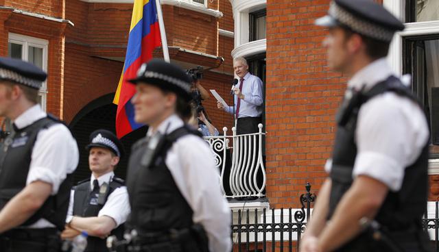 FILE - In this Sunday, Aug. 19, 2012 file photo, surrounded by British police WikiLeaks founder Julian Assange, center, makes a statement to the media and supporters from a window of Ecuadorian Embassy in central London. Julian Assange, founder of WikiLeaks, has won his battle against extradition to Sweden, which wanted to question him about a rape allegation. He has spent nearly five years inside the Embassy of Ecuador in London to avoid being sent to Sweden, which announced Friday, May 19, 2017 that the investigation has been discontinued. (AP Photo/Sang Tan, file)