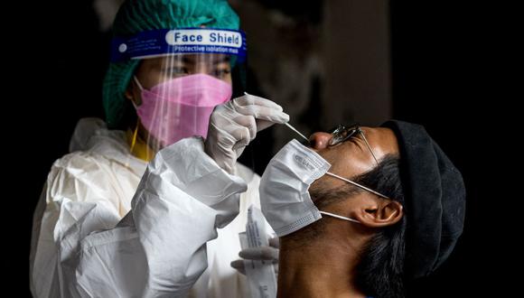 Un trabajador de un bar se somete a una prueba de coronavirus covid-19 antes del inicio de su turno en Bangkok, Tailandia, el 6 de enero de 2022. (Jack TAYLOR / AFP).