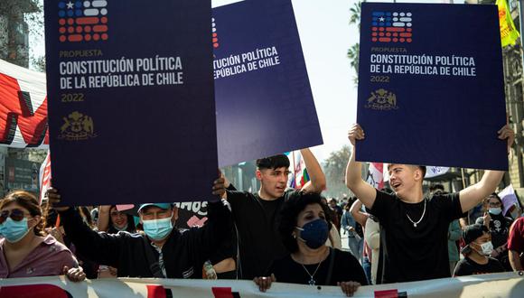 En esta foto de archivo tomada el 20 de agosto de 2022, personas sostienen carteles durante una marcha en apoyo a la nueva Constitución de Chile. (MARTÍN BERNETTI / AFP).
