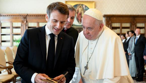 El Papa Francisco intercambiando regalos con el presidente francés Emmanuel Macron durante una audiencia privada en el Vaticano. (Foto de VATICAN MEDIA/AFP)