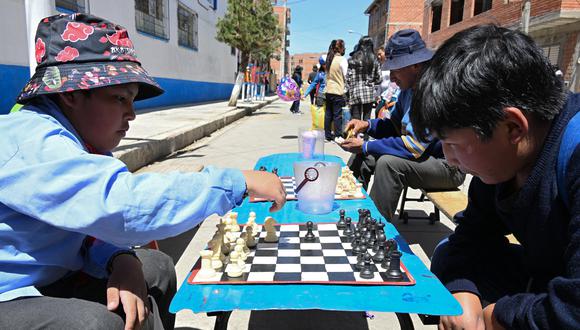 Miguel Tito Turpo, 11 (iz.) y su hermano Isaac Esteban Turpo, 12, juegan al ajedrez en una calle de Villa Tejada Triangular, en El Alto, Bolivia.