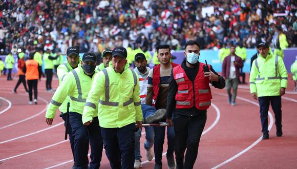 Los miembros del equipo de seguridad llevan a un aficionado al fútbol herido a un área de emergencia en el Estadio Internacional de Basora luego de una estampida antes del partido final de la Copa del Golfo Arábigo entre Irak y Omán, el 19 de enero de 2023. (Foto: Hussein FALEH / AFP)