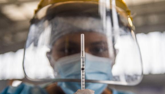 Un trabajador de salud prepara una dosis de la vacuna Pfizer-BioNTech contra COVID-19 para inocular a un anciano, en un centro de vacunación de Lima el 23 de abril de 2021. (Foto: ERNESTO BENAVIDES / AFP)