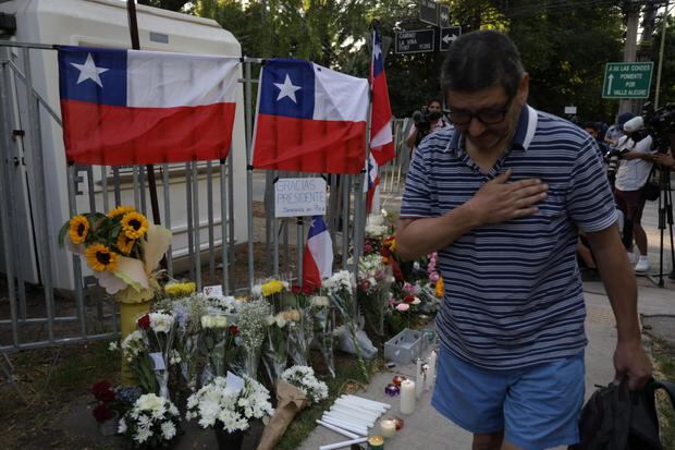 Chilenos dejan ofrendas florales a la entrada de la casa del expresidente chileno Sebastián Piñera. (EFE/ Ailen Díaz).