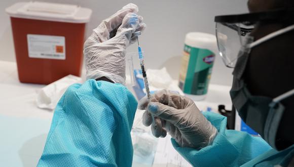 Imagen referencial. Una persona alista una dosis de la vacuna contra el coronavirus hecha por Pfizer. AP