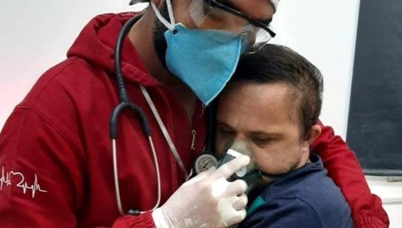 Gracias al abrazo del enfermero, el paciente con COVID-19 pudo usar la máscara de oxígeno. (Foto: Centro de Apoio Geriátrico / Facebook)