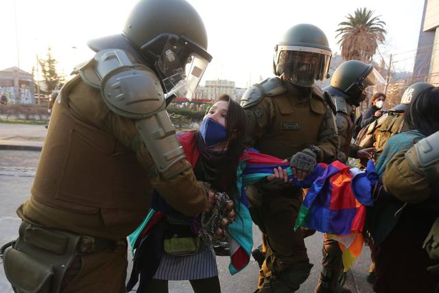 Una joven mujer es detenida por agentes policiales durante las protestas en contra del gobierno chileno y a favor del pueblo Mapuche. (EFE/Elvis González).