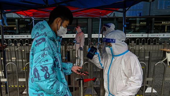 Un pasajero muestra su código de salud QR en la entrada de la estación de tren de Hongqiao en Shanghái el 5 de diciembre de 2022.