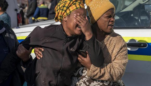 Una mujer llora en la escena de un tiroteo nocturno en un bar en Soweto, Sudáfrica, el domingo 10 de julio de 2022. (Foto AP/Shiraaz Mohamed).