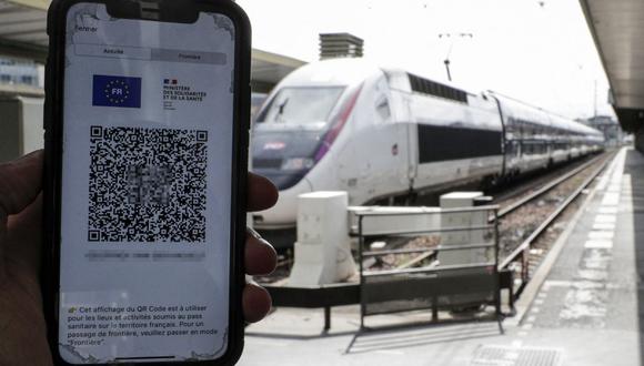 Un pasajero muestra su pase de salud coronavirus Covid-19 en un teléfono móvil en la estación de tren de Lyon, Francia, el 9 de agosto de 2021. (Foto de GEOFFROY VAN DER HASSELT / AFP).