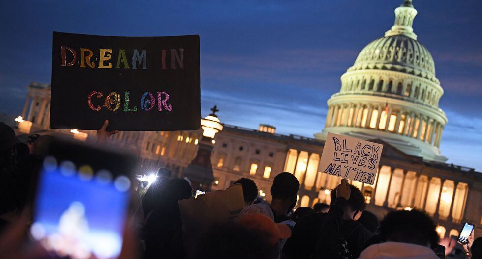 Los manifestantes sostienen carteles mientras marchan fuera del Capitolio en Washington, DC para exigir justicia por la muerte de George Floyd, un hombre negro que falleció después de que un policía blanco se arrodilló en su cuello durante varios minutos. (Foto de Eric BARADAT / AFP).