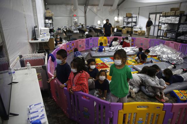 Niños migrantes no acompañados, de 3 a 9 años, ven televisión dentro de un corralito en el centro de detención del Departamento de Seguridad Nacional de Donna, en Texas, Estados Unidos. (Foto de Dario Lopez-Mills / POOL / AFP).