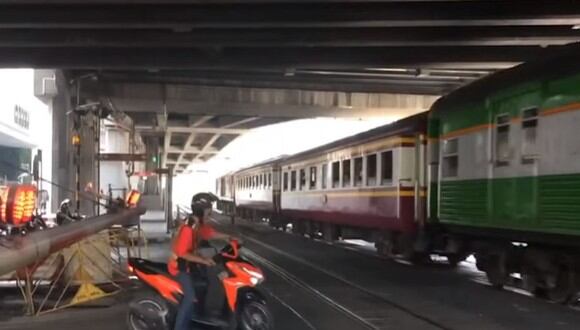 Un motociclista se dio un gran golpe en el rostro por querer pasarse un paso a nivel mientras un ferrocarril circulaba por las vías del tren | Foto: Captura de video / Viral Press
