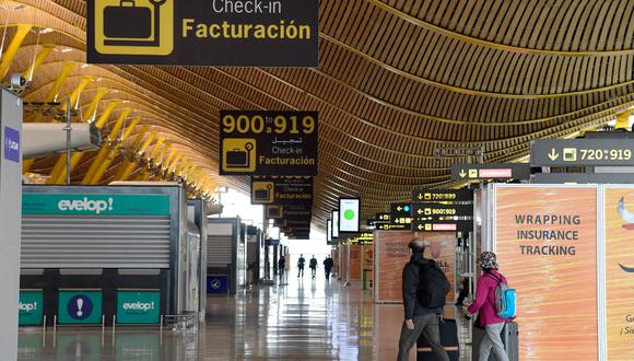 La gente camina en un pasillo vacío de la Terminal 4 en el aeropuerto Adolfo Suárez de Madrid-Barajas el 7 de abril de 2020, en plena pandemia de coronavirus en España. (JAVIER SORIANO / AFP).