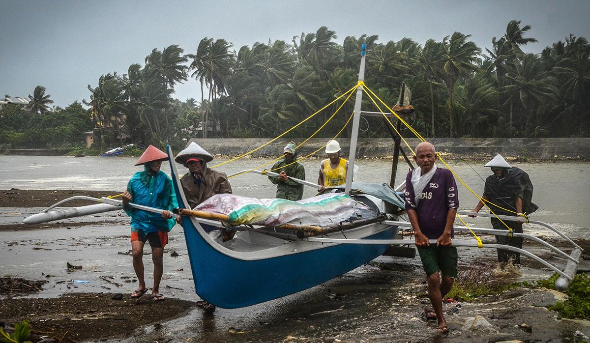 Los pescadores llevan un bote a tierras más altas en Baybay, Samar oriental, el 24 de diciembre de 2019, después de que el tifón Phanfone azotara el centro de Filipinas. (Foto: AFP)