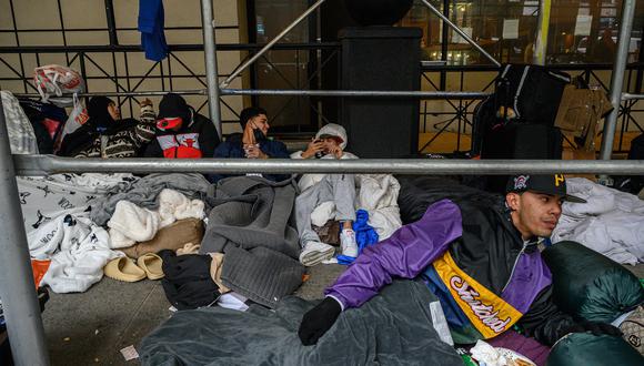 Migrantes acampan afuera de un hotel donde habían estado alojados anteriormente, en el vecindario Hells Kitchen de Nueva York el 31 de enero de 2023. (Foto de Ed JONES / AFP)