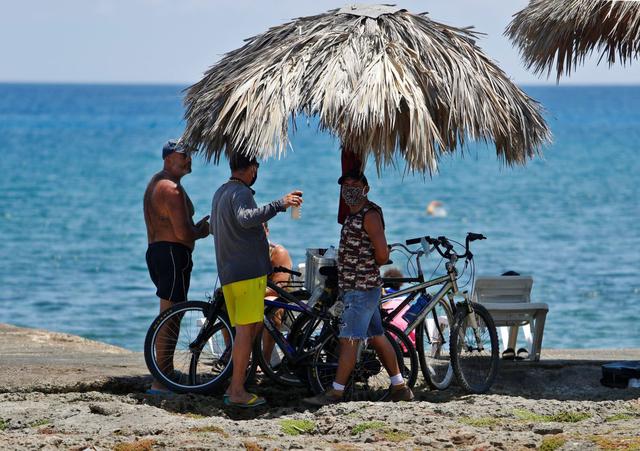 Varias personas disfrutan del mar este viernes, durante el primer día de reapertura en la capital de Cuba desde que comenzó la pandemia de coronavirus. (EFE/Yander Zamora).