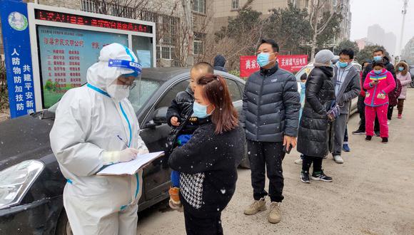 Residents queue to undergo nucleic acid tests for the Covid-19 coronavirus during a light snowfall in Anyang in China's central Henan province on January 21, 2022. (Photo by AFP) / China OUT
