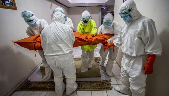 Un equipo forense lleva el cuerpo de un paciente de coronavirus Covid-19 que murió en su casa durante en Bogor, Java Occidental, Indonesia. (Foto de ADITYA AJI / AFP).