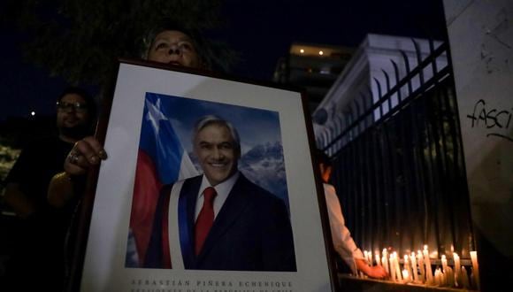 Militantes de Renovación Nacional encienden velas en la sede del partido en apoyo al expresidente de Chile Sebastián Piñera. (EFE/ Ailen Díaz).