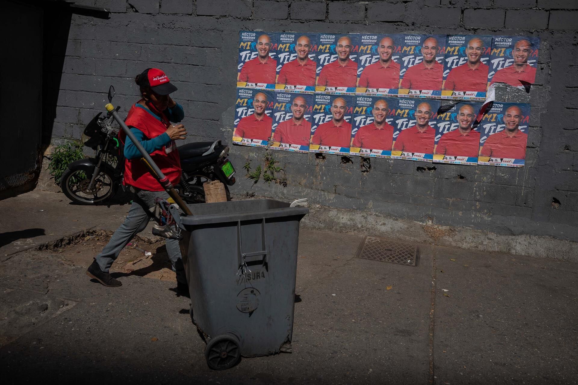 A woman walks in front of the propaganda of a Chavista candidate for the local elections.  (EFE / RAYNER PEÑA R.).