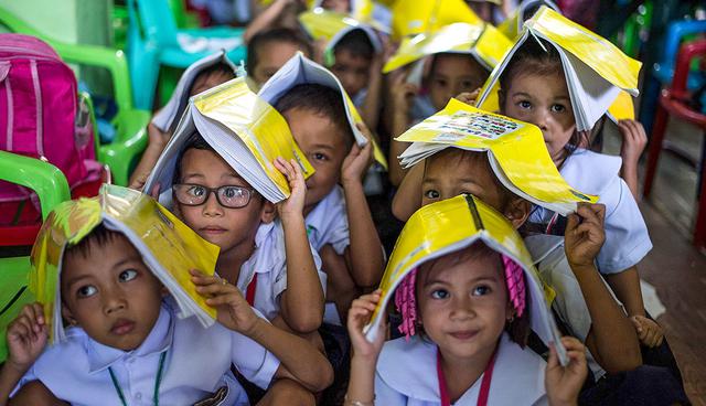 Schoolchildren from the Corazon Aquino Elementary School participate in a nationwide simultaneous earthquake drill in Manila on June 29, 2017.  The nationwide drill is part of the Philippine government's disaster preparedness programme and is held quarterly.  / AFP / NOEL CELIS