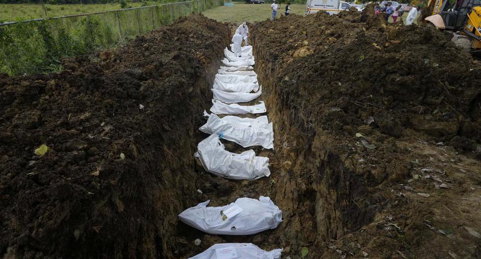 Un equipo forense entierra a un grupo de migrantes que murieron tratando de cruzar la brecha del Darién, en una fosa común en el cementerio de Guayabillo en Agua Fría, Panamá, el jueves 30 de septiembre de 2021. (Foto AP/Arnulfo Franco).