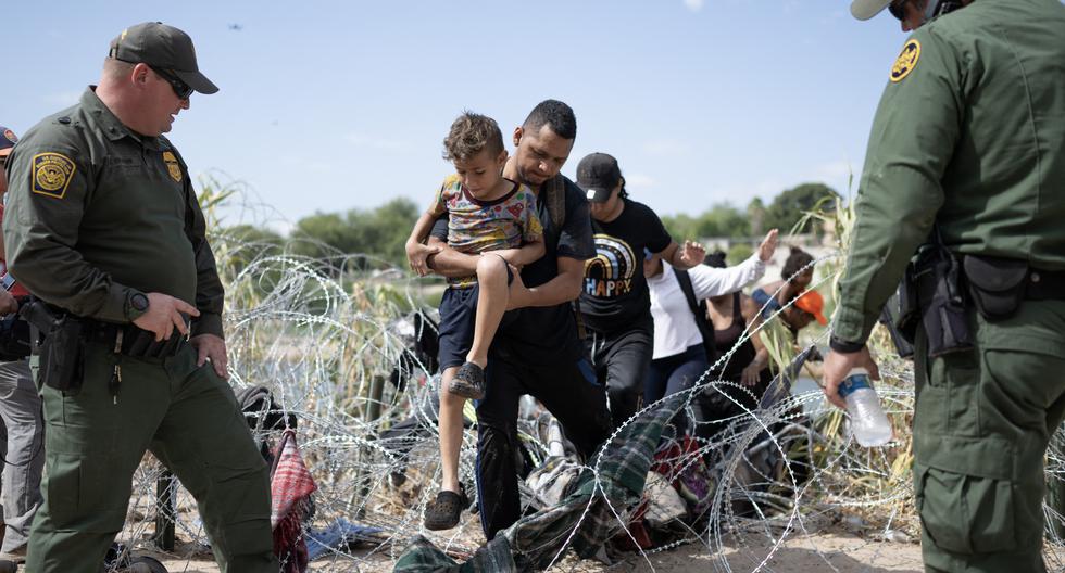El personal de Aduanas y la Patrulla Fronteriza de Estados Unidos observa cómo inmigrantes ásan a través de alambre de púas en Eagle Pass, Texas, el 25 de septiembre de 2023. (Foto de ANDREW CABALLERO-REYNOLDS / AFP).