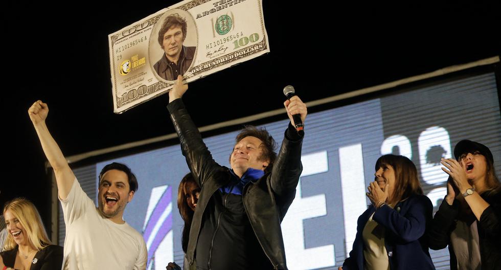 Javier Milei levanta un billete falso de 100 dólares con su imagen durante el cierre de su campaña electoral en Córdoba. (Foto: AFP).