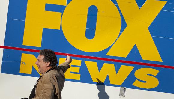 Un hombre hace un gesto con el dedo medio hacia un camión satelital de Fox News antes del "Rally to Restore Sanity and/or Fear" en el National Mall el 30 de octubre de 2010 en Washington, DC. (Foto de BRENDAN SMIALOWSKI / AFP)