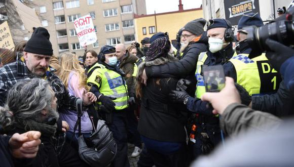 La policía intenta dispersar a la multitud mientras la gente participa en una protesta anti-cierre en Estocolmo, Suecia. (Foto: EFE / EPA / HENRIK MONTGOMERY SUECIA OUT).
