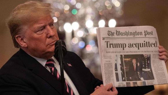 "Absuelto". Trump mostró uno de los diarios que reseñaron el resultado del juicio de impeachment al que fue sometido. (Foto: AFP)