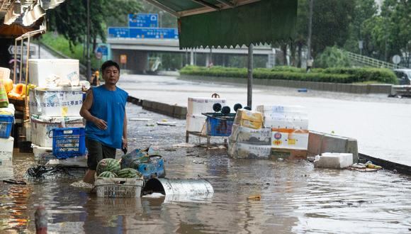 Un hombre se encuentra en una carretera inundada en Hong Kong el 8 de septiembre de 2023. (Foto de Bertha WANG / AFP)