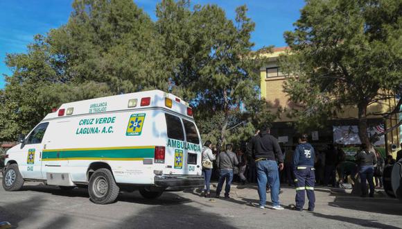 Paramédicos y familiares se reúnen fuera de la escuela primaria, donde un niño de 11 años disparó y mató a su maestra e hirió a otras seis personas antes de suicidarse en Torreón, estado de Coahuila. (Foto: AFP).