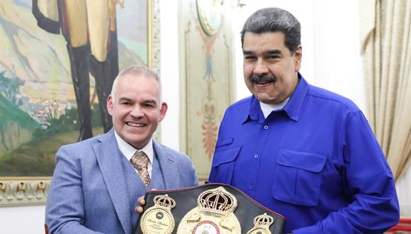 El presidente de la Asociación Mundial de Boxeo (AMB), Gilberto Mendoza, entrega el título de campeón honorario al presidente de Venezuela, Nicolás Maduro. (EFE/ Prensa Miraflores).