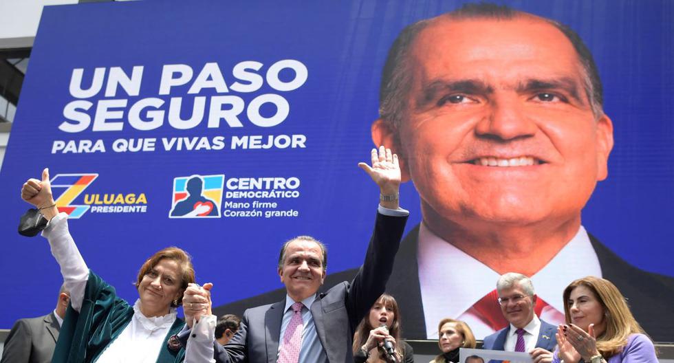 El candidato presidencial colombiano por el partido Centro Democrático, Oscar Ivan Zuluaga (C), y su compañera de fórmula, Alicia Eugenia Silva (izq), registran su candidatura en la Oficina de Registro en Bogotá, el 9 de marzo de 2022. (Raúl ARBOLEDA / AFP).