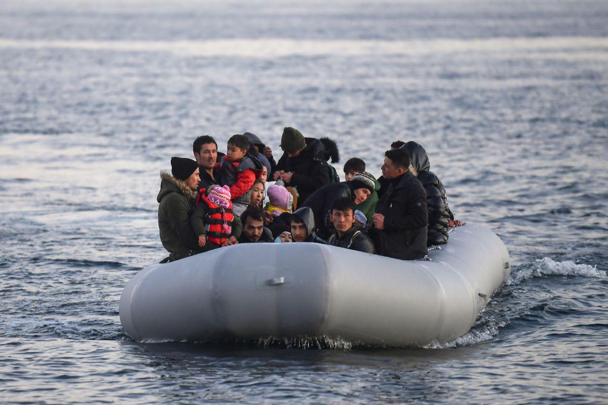 Los refugiados y los migrantes a bordo de un bote inflable llegan a la isla griega de Lesbos. (AFP).