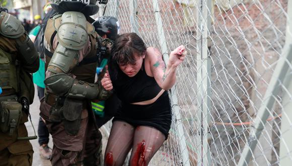 La policía de Chile detiene a una manifestante herida durante una protesta en Santiago. (REUTERS/Henry Romero).