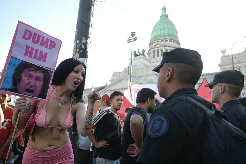 A sex worker with a sign in front of the police.  (GET IMAGES).