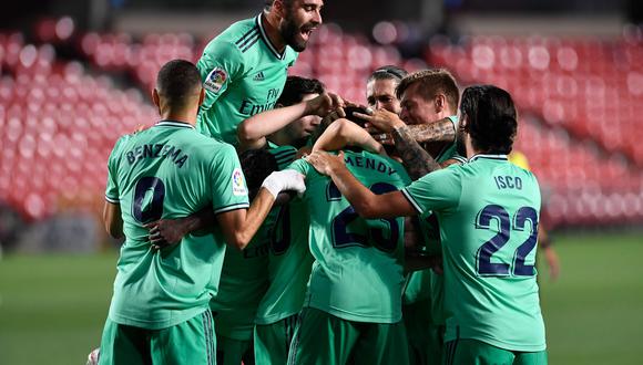 Real Madrid's players celebrate after French defender Ferland Mendy scored during the Spanish league football match Granada FC vs Real Madrid CF at Nuevo Los Carmenes stadium in Granada on July 13, 2020. / AFP / JORGE GUERRERO
