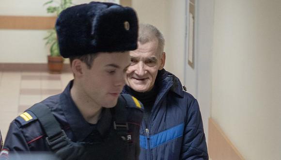 Yury Dmitriev es escoltado por un policía ruso en el tribunal. (GETTY IMAGES).